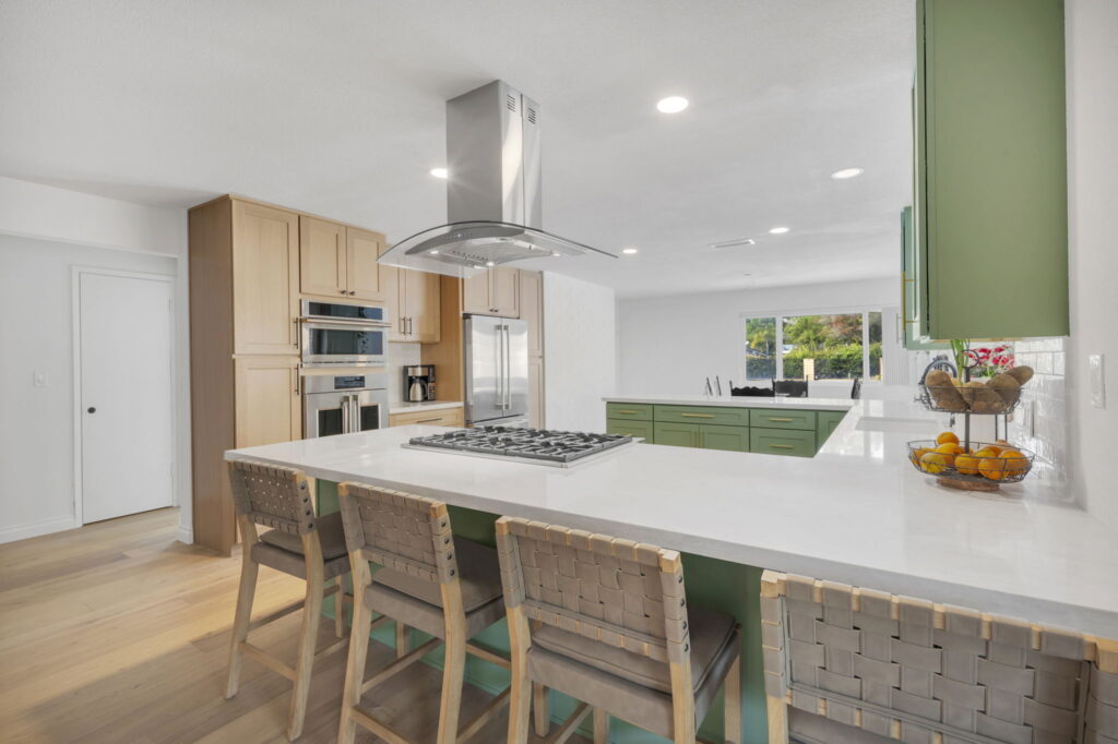 Sage green kitchen remodel with white quartz island and light wood cabinets in San Diego