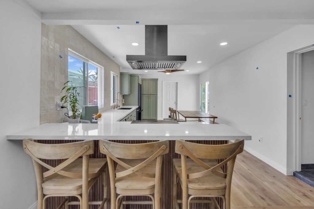 Kitchen island with quartz counters and rattan bar stools in San Diego