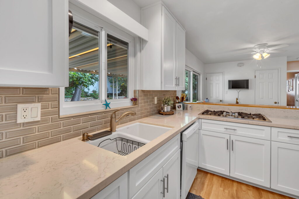 White shaker kitchen with brown subway tile backsplash in San Diego