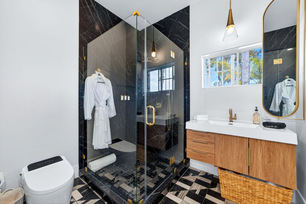 Luxury bathroom remodel with black marble walk-in shower and gold fixtures in Escondido CA