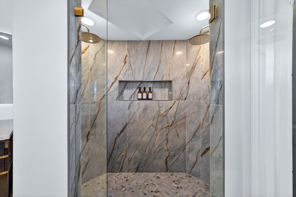 Walk-in marble shower with brushed gold rain head, bathroom remodeling in San Diego County