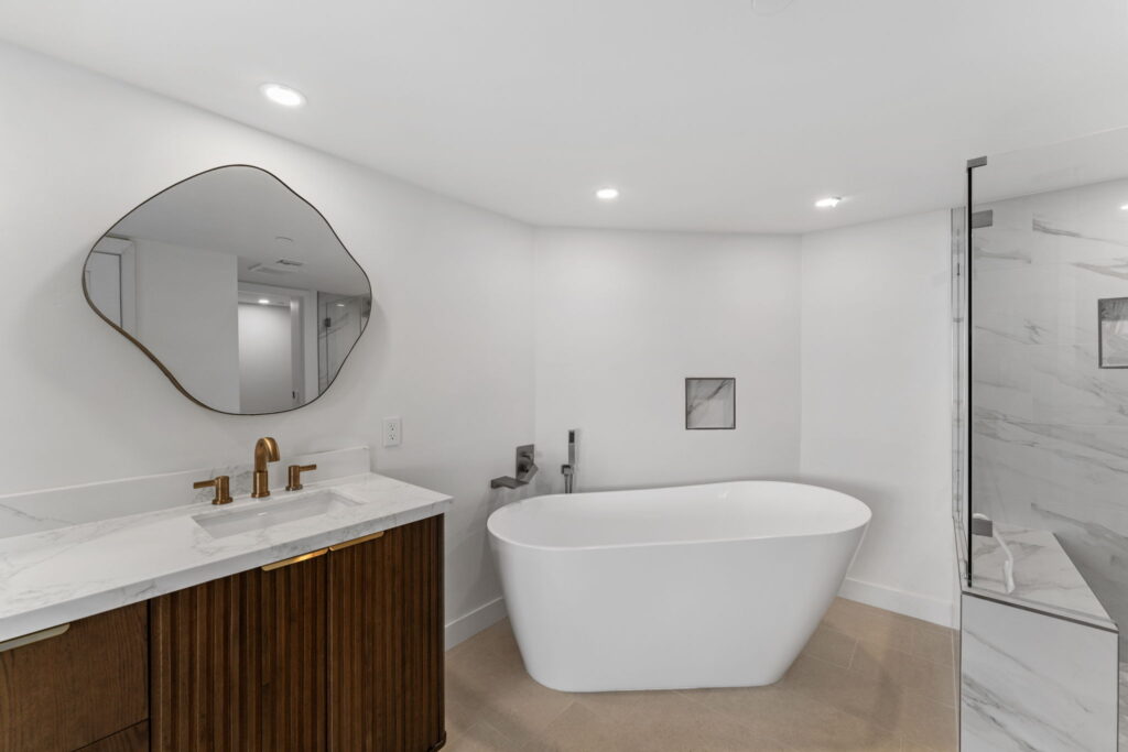 Modern bathroom renovation with soaking tub and walk-in glass shower by PBH Builders