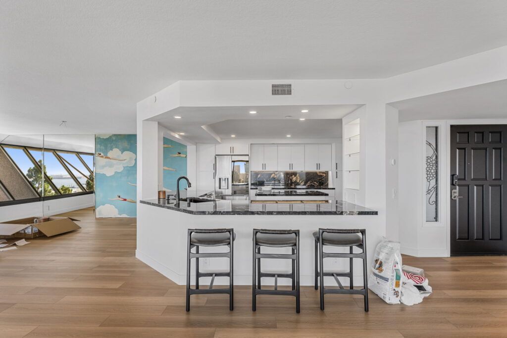 Kitchen remodel with breakfast bar seating and custom white cabinetry in San Diego